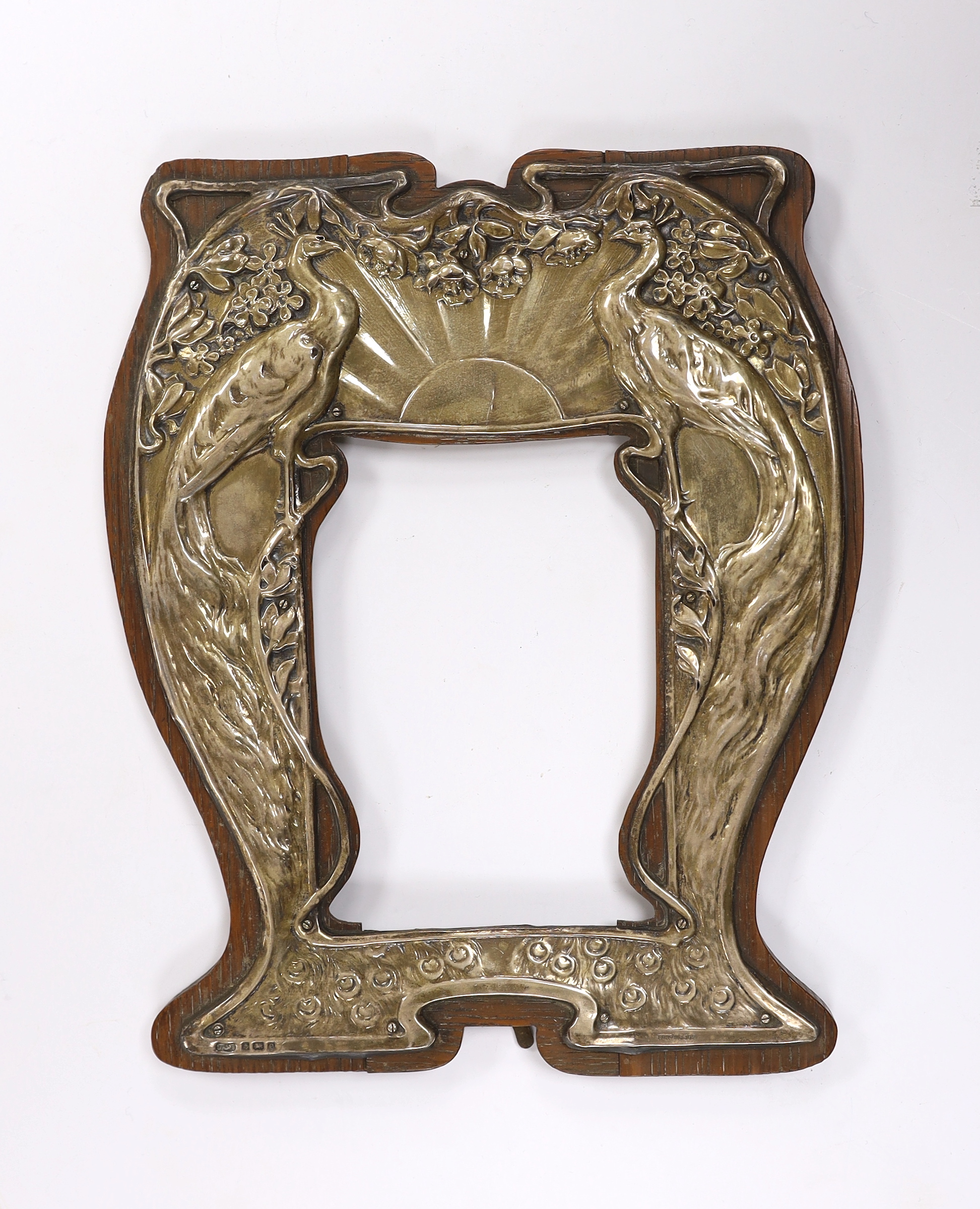 An Edwardian Art Nouveau repousse silver mounted photograph frame, decorated with peacocks, Henry Charles Freeman, Birmingham, 1904, overall 23.8cm, (no glass).